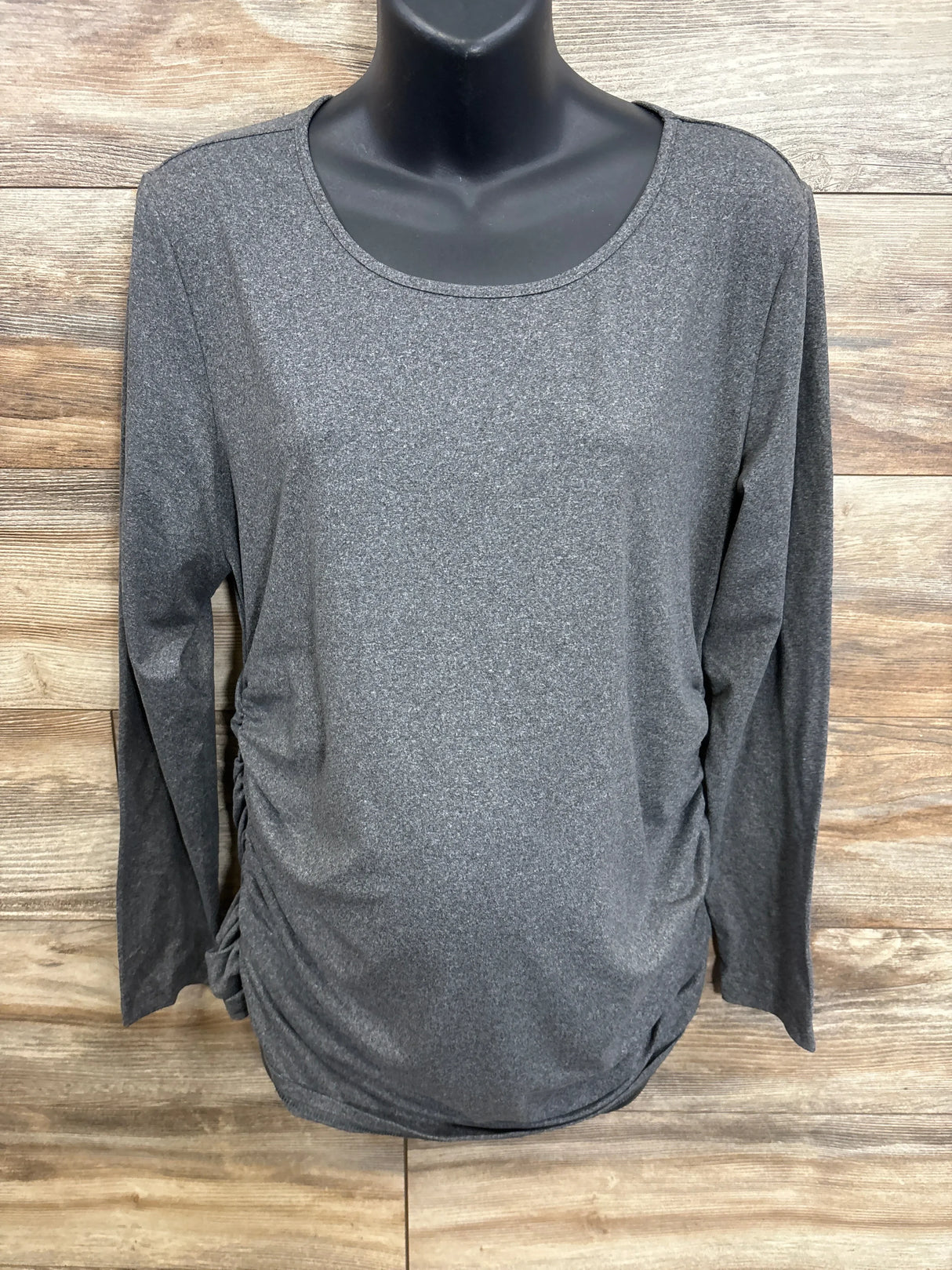 Gray long sleeve maternity shirt with ruched sides on a mannequin against wood background