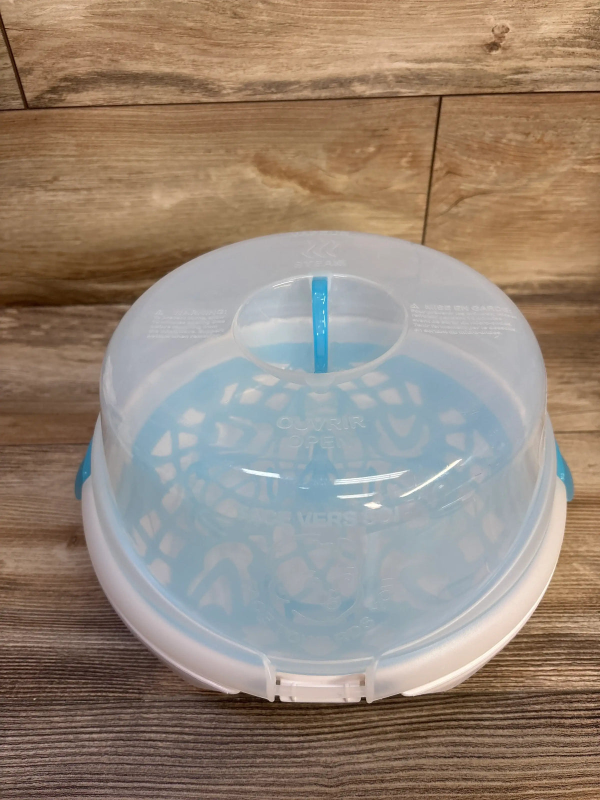 Front view of Munchkin Steam Guard microwave bottle sterilizer with translucent lid and blue tray