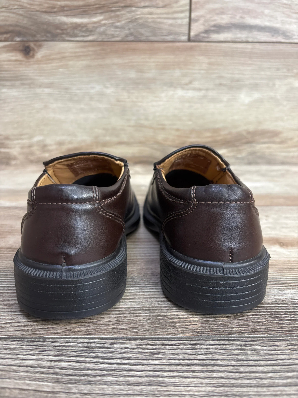 Rear view of brown leather children's dress shoes on wooden floor for kids resale
