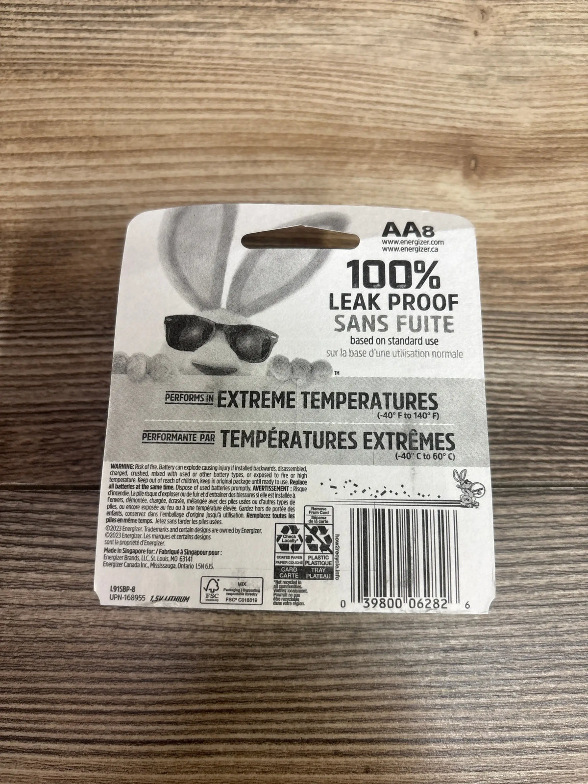 Back of Energizer AA lithium 8-pack showing 100 percent leak proof text and barcode on wood surface