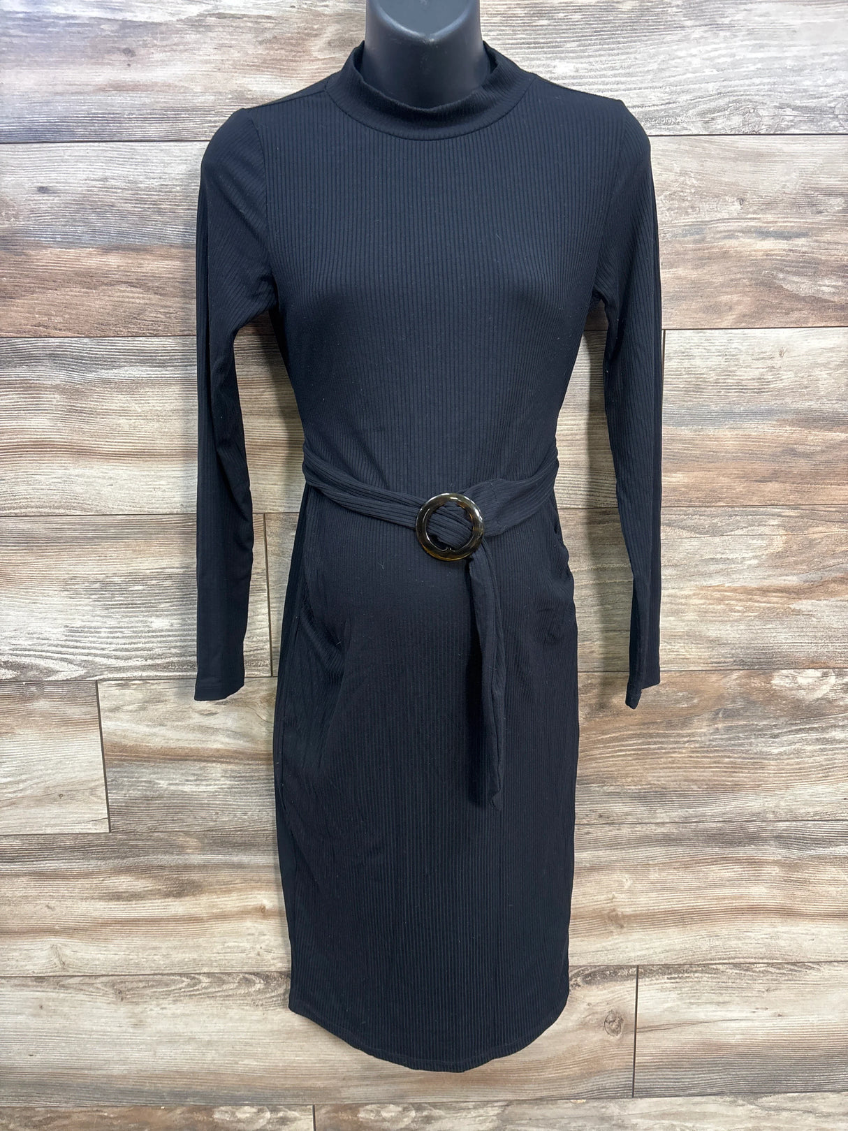 Black ribbed knit midi dress with belt and long sleeves on mannequin, wood background