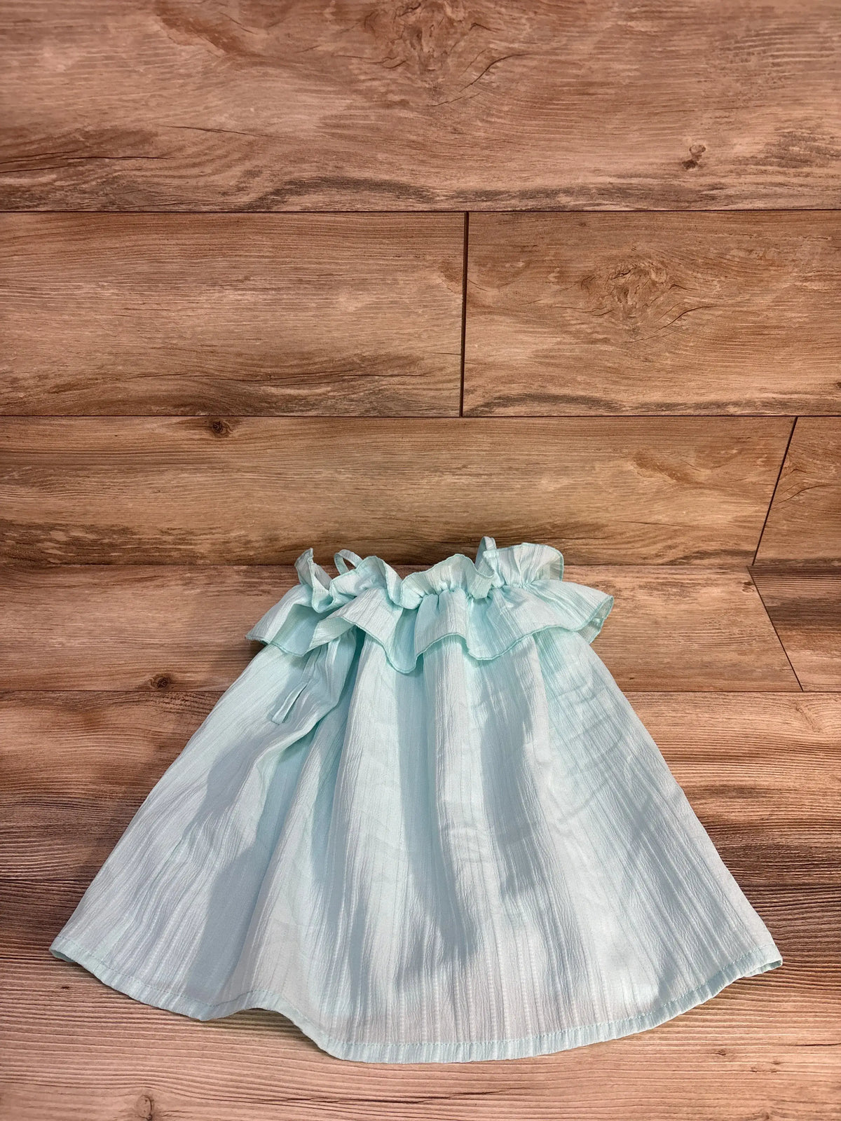 Front view of Shein ruffle dress in blue, size 12-18 months, showcasing ruffled neckline and sleeves on a wood floor