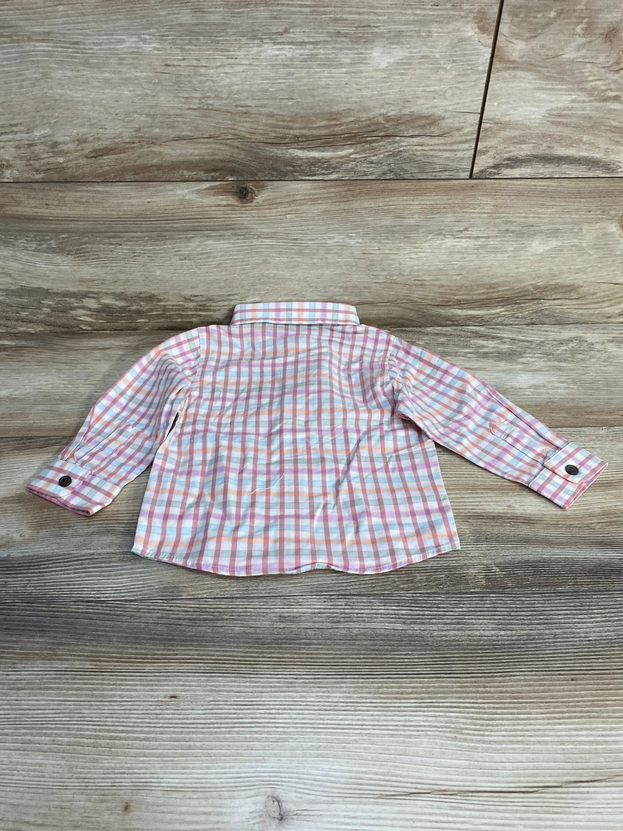 Back of Cat and Jack pink and white plaid baby button-up shirt size 12M showing collar and cuffs on wood background