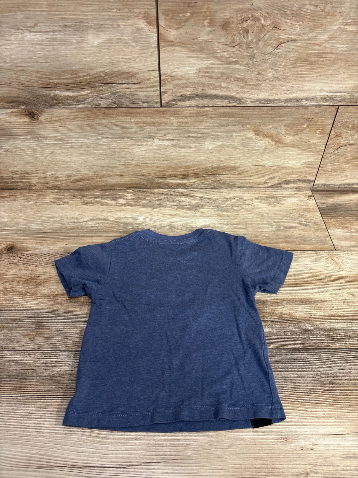 Back view of Izzy & Luke Shoots toddler T-shirt in navy, size 12-18 months showing plain back on wooden floor