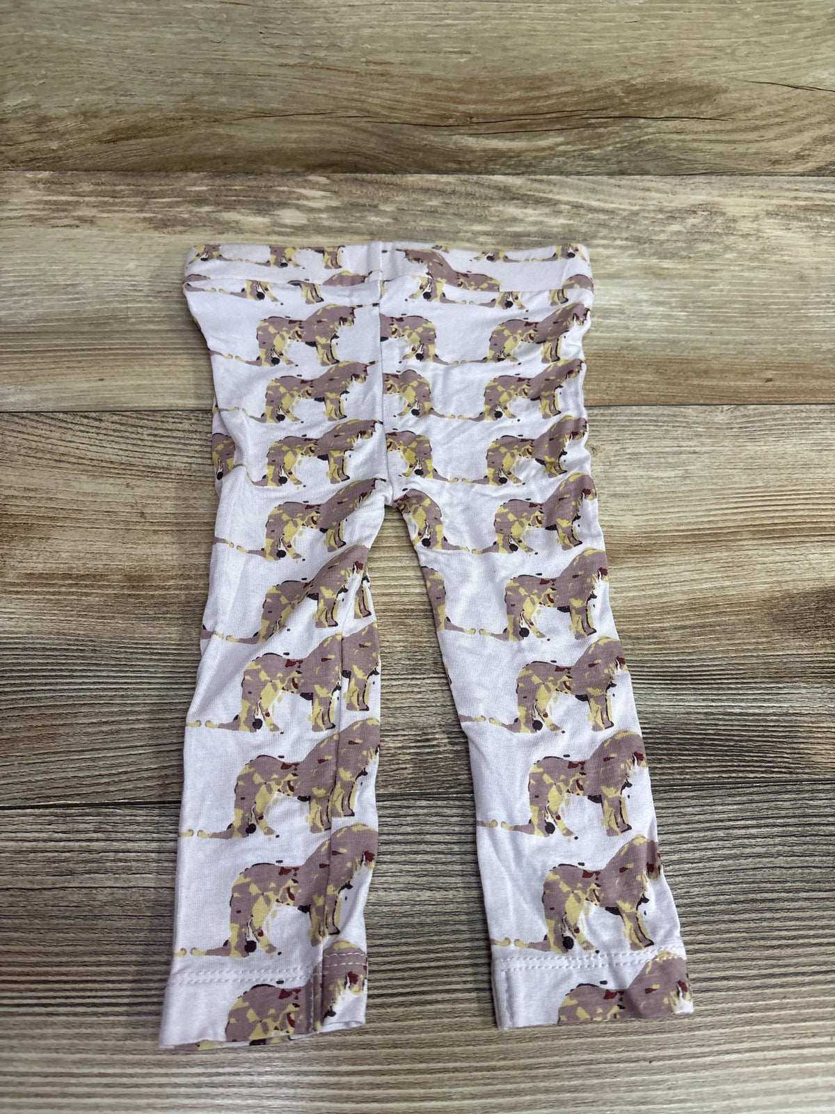 Kate Quinn Bamboo Unicorn Pants in pink for infants, size 12-18m, on a wood background