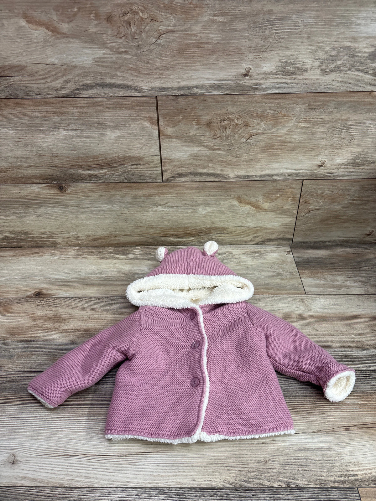 Pink Baby Gap sherpa lined hooded knit cardigan for babies 6-12 months on wood background