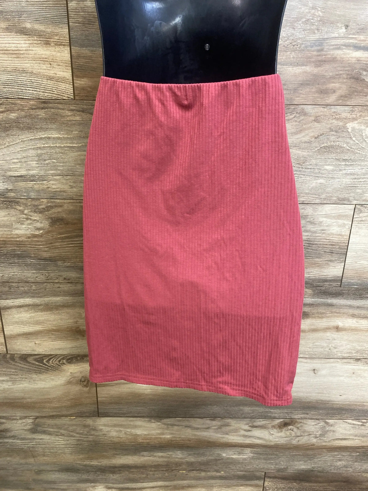 Front view of the red Shein maternity ribbed skirt in size medium, showing its elastic waistband and ribbing on a wood floor