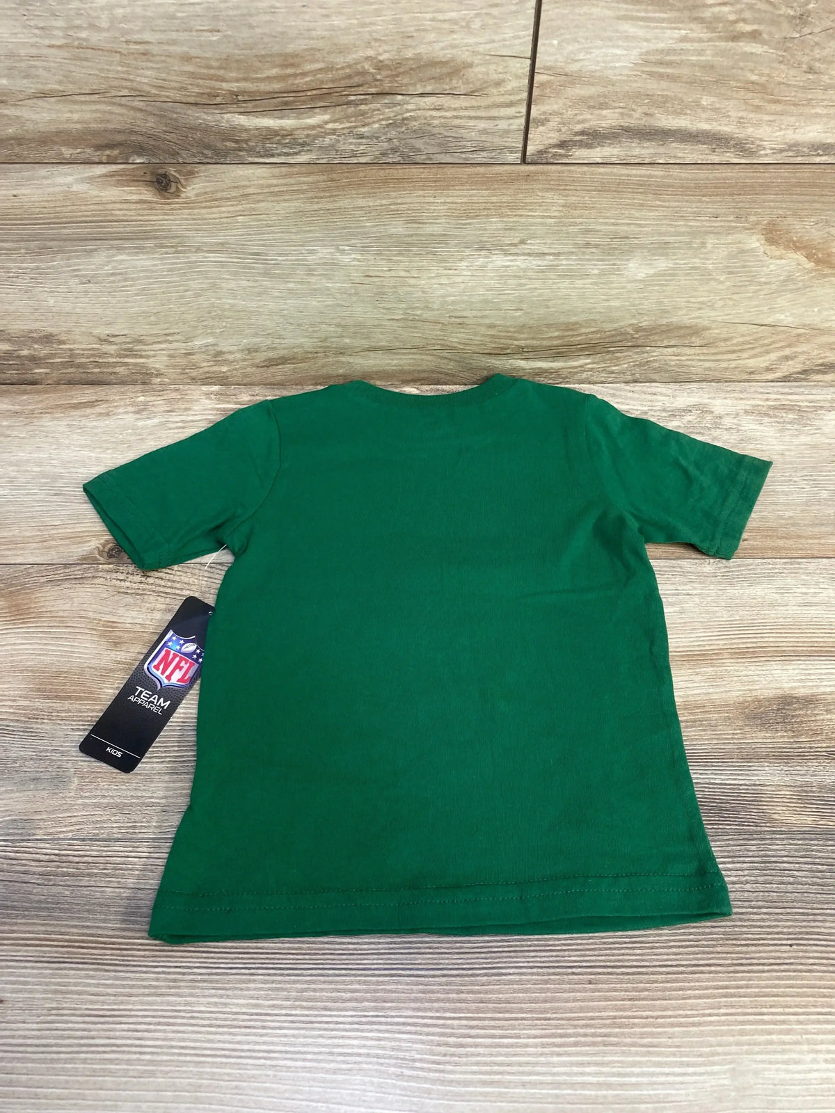 Back view of New York Jets toddler t-shirt (size 3T) showcasing plain green back and attached NFL hang tag on wood background