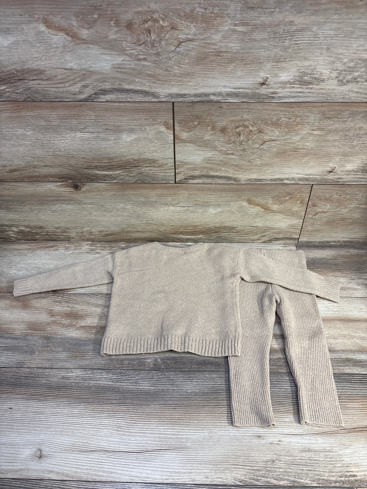 Flat lay of Cat & Jack tan knit sweater and ribbed pants set showing textured knit and ribbed hems on wood floor background