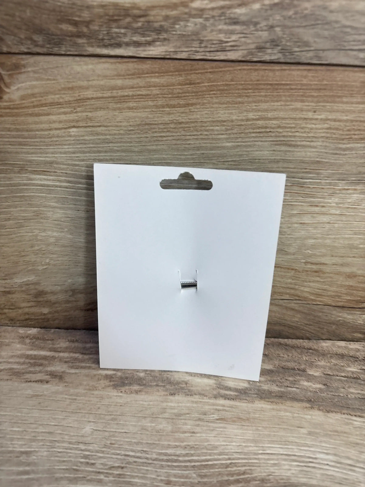 Back view of NEW Birthday Hair Bow White showcasing its alligator clip on a white card over a wood plank background