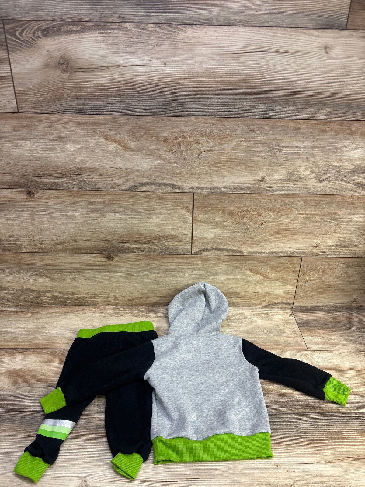 Top-down view of Star Wars Yoda sweatshirt and joggers set showing gray, black, and green color blocking on a wood floor