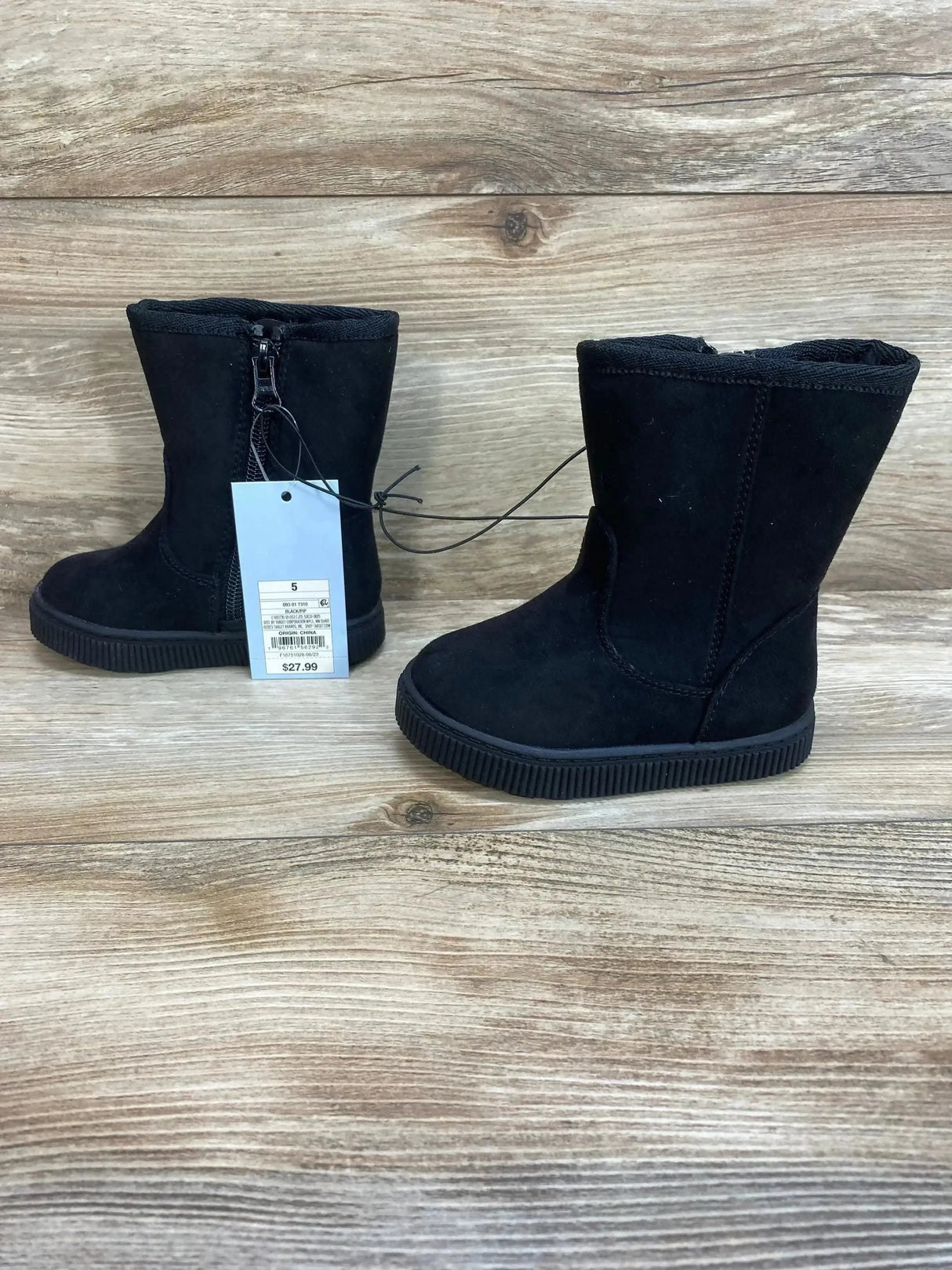 Side view of toddler Cat & Jack black Pip shearling-style zipper boots with ribbed rubber sole on wooden background