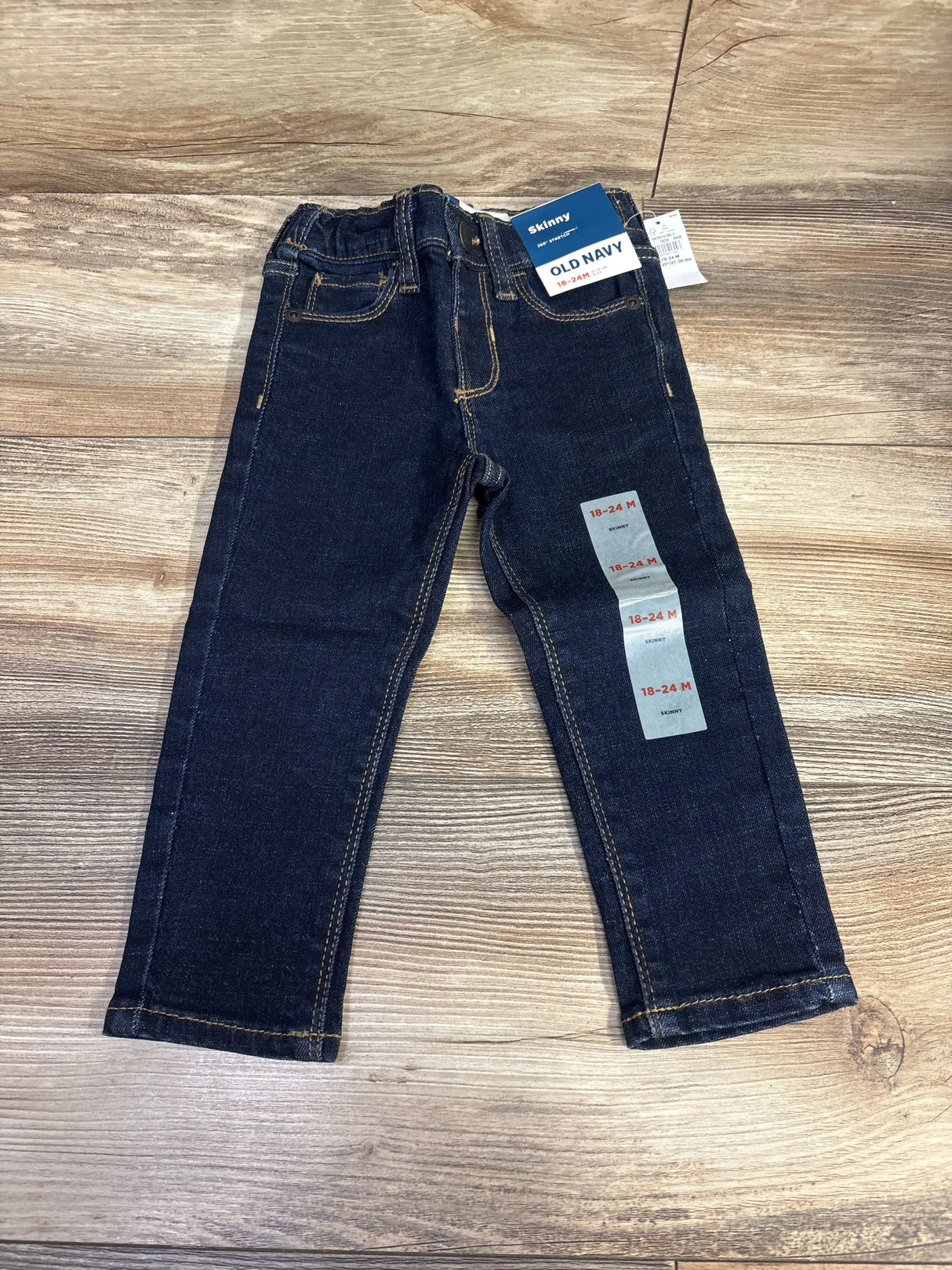 Old Navy toddler skinny jeans size 18-24 months, dark wash, displayed on wood background