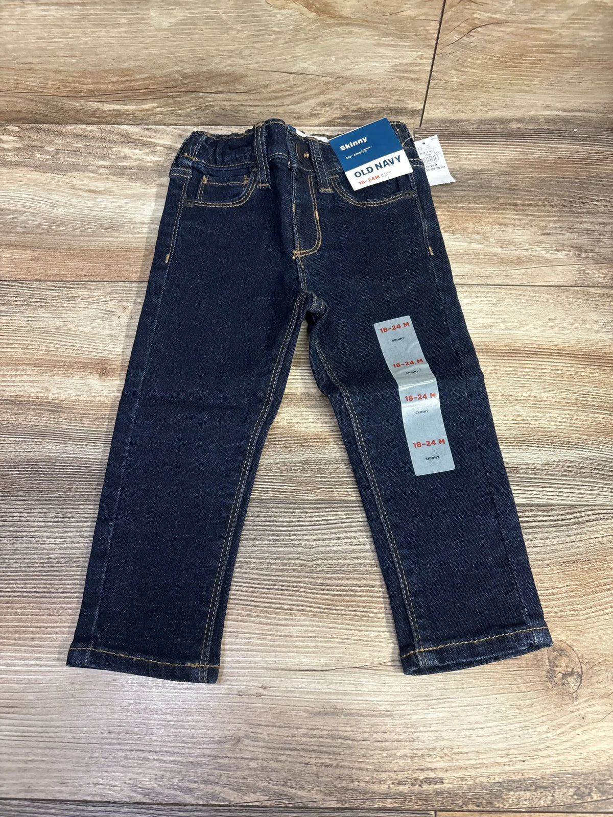Old Navy toddler skinny jeans size 18-24 months, dark wash, displayed on wood background