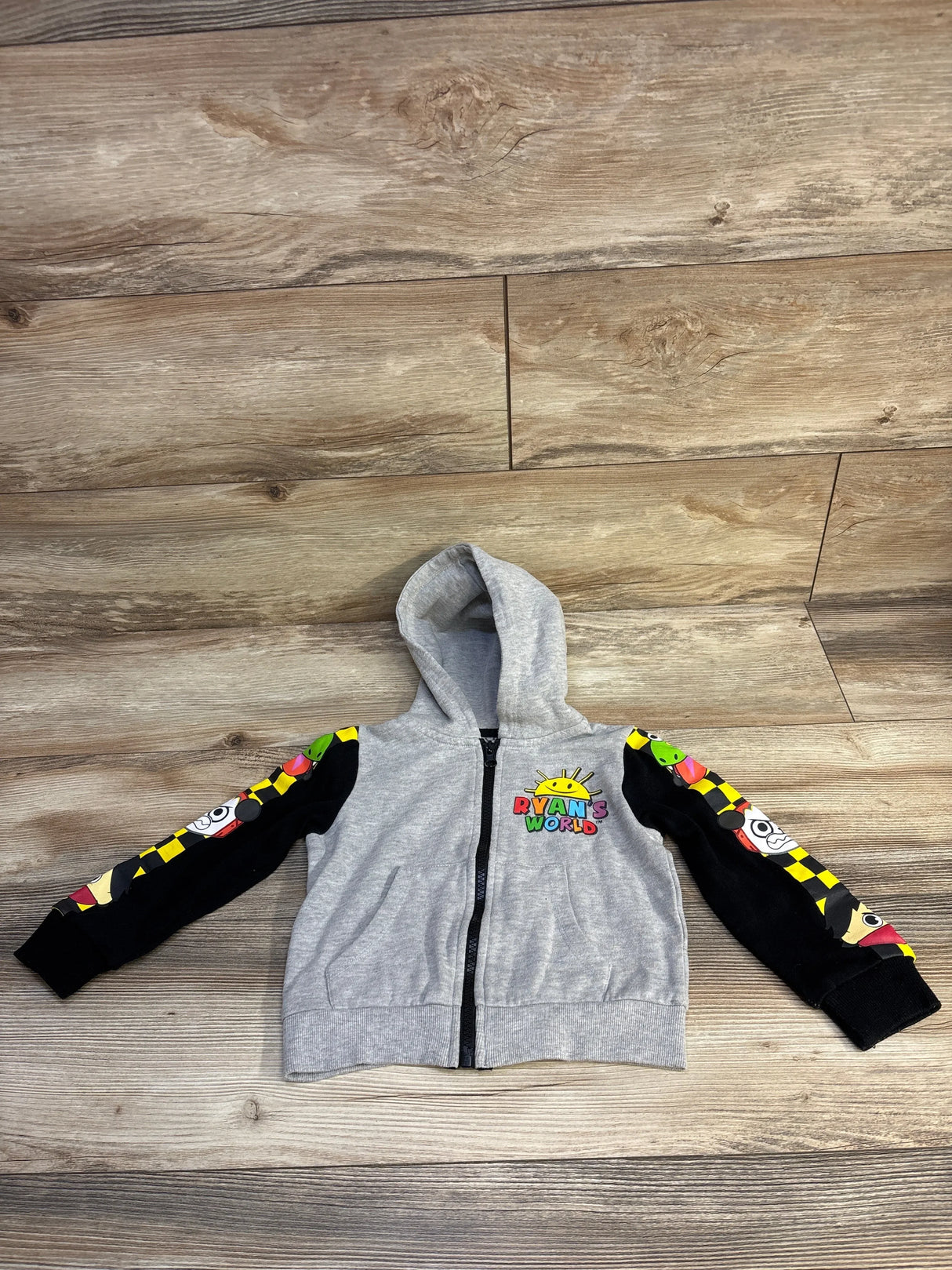 Gray Ryan's World kids hoodie with cartoon character sleeves on wood floor