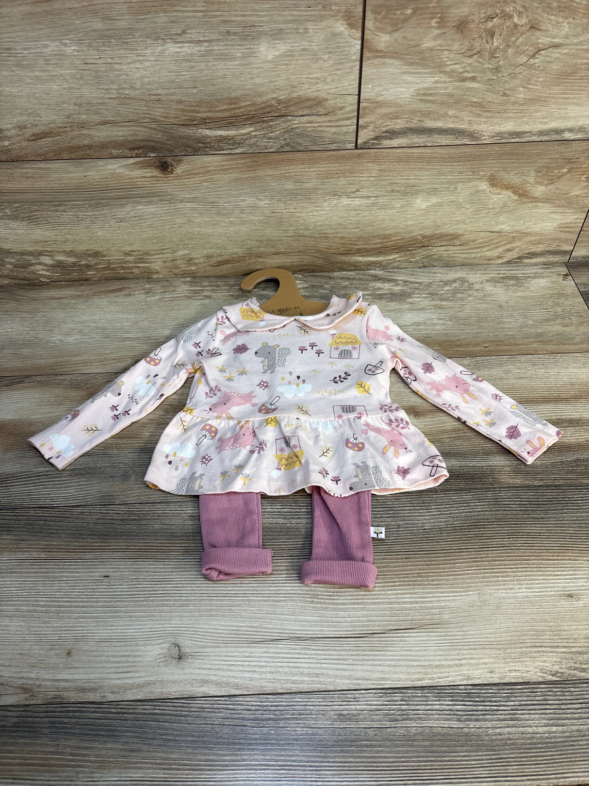 Girls' long sleeve dress with animal print and pink leggings set on wood background