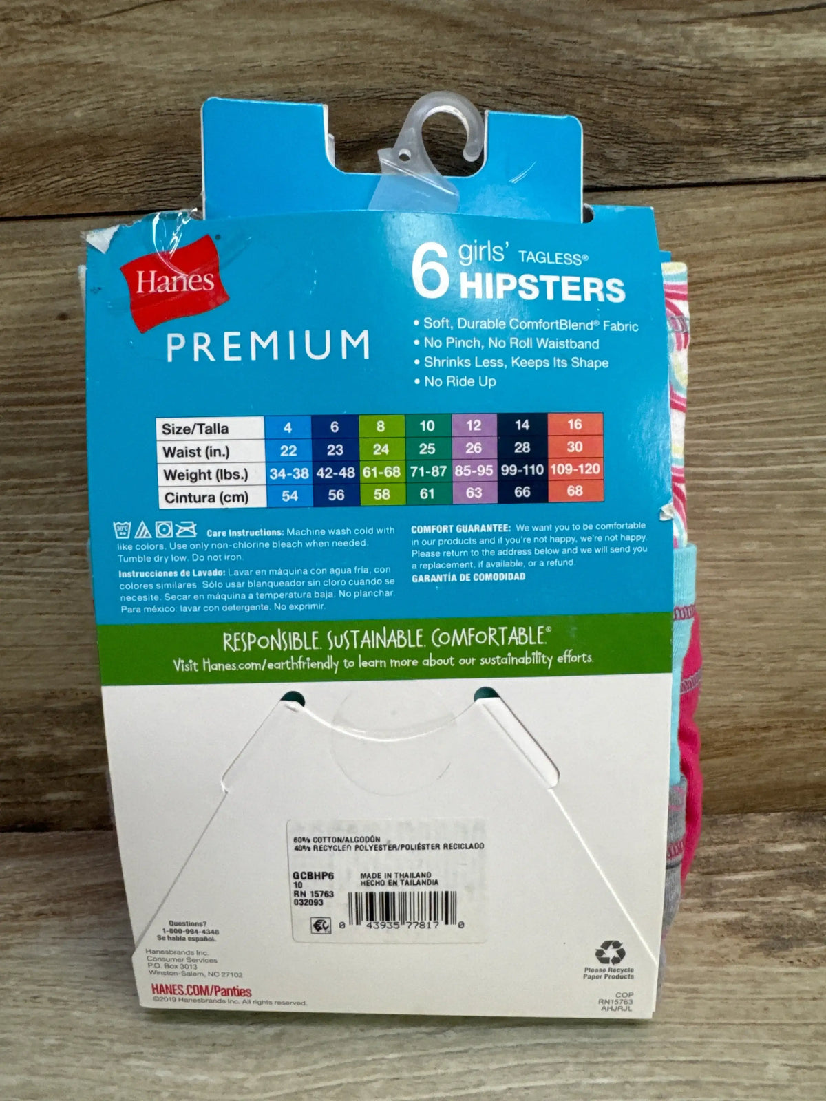 Back view of Hanes Premium ComfortBlend girls tagless hipsters six pack showing size 10 chart on wood background