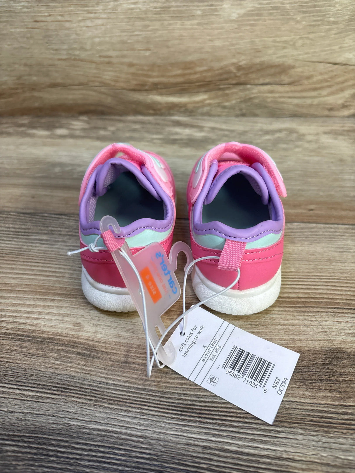 Rear view of Just One You Butterfly toddler sneakers size 4C in pink and purple showing soft soles and retail tags on wooden floor