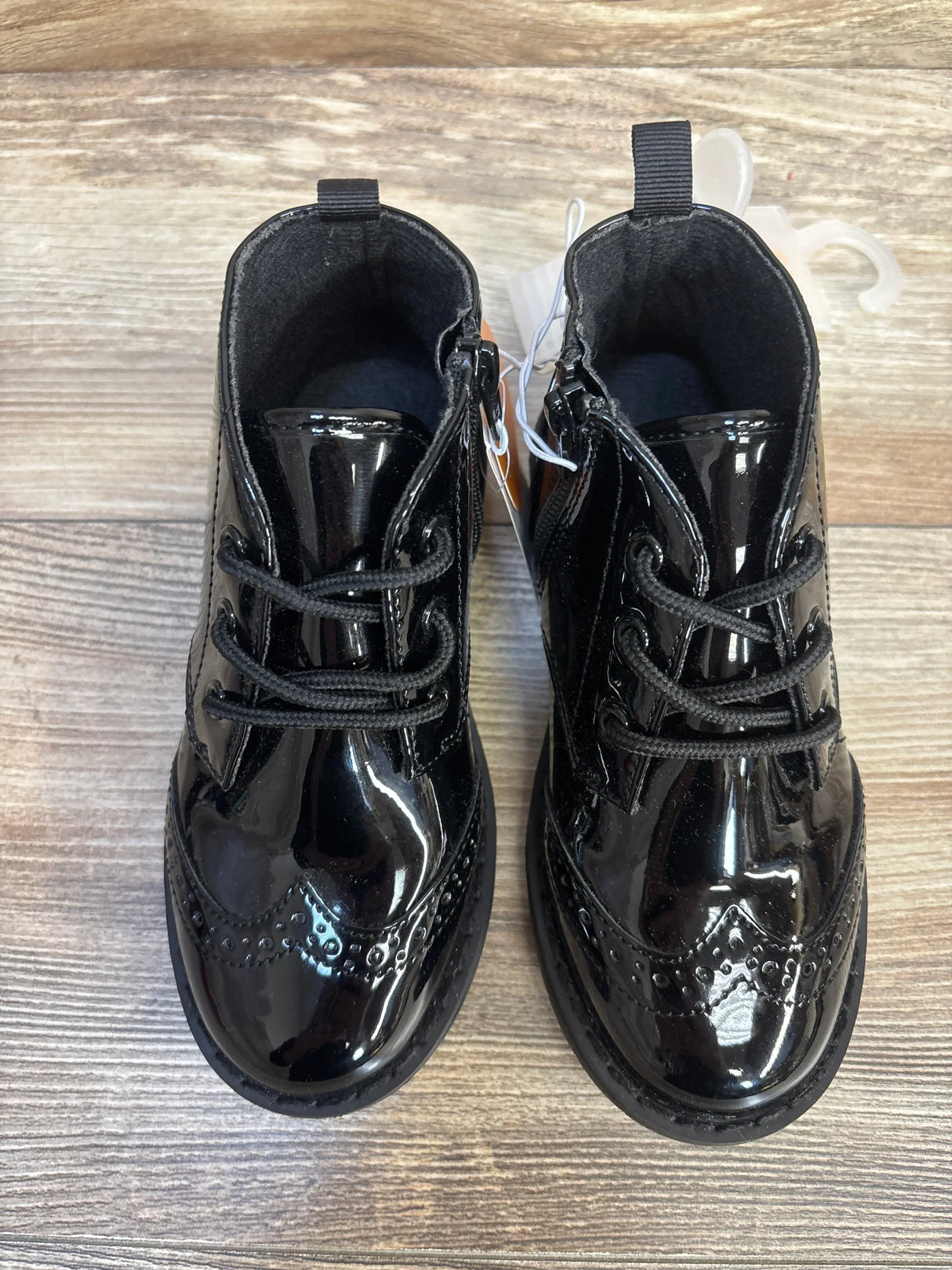 Shiny black patent leather toddler dress shoes with laces and side zippers, perfect for kids' formal wear.