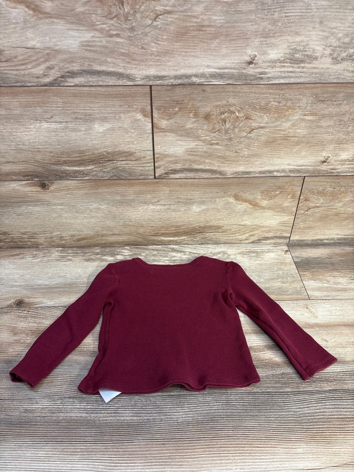 Flat lay of Old Navy burgundy toddler waffle-knit long-sleeve shirt size 3T showing textured knit and scalloped hem on wood background