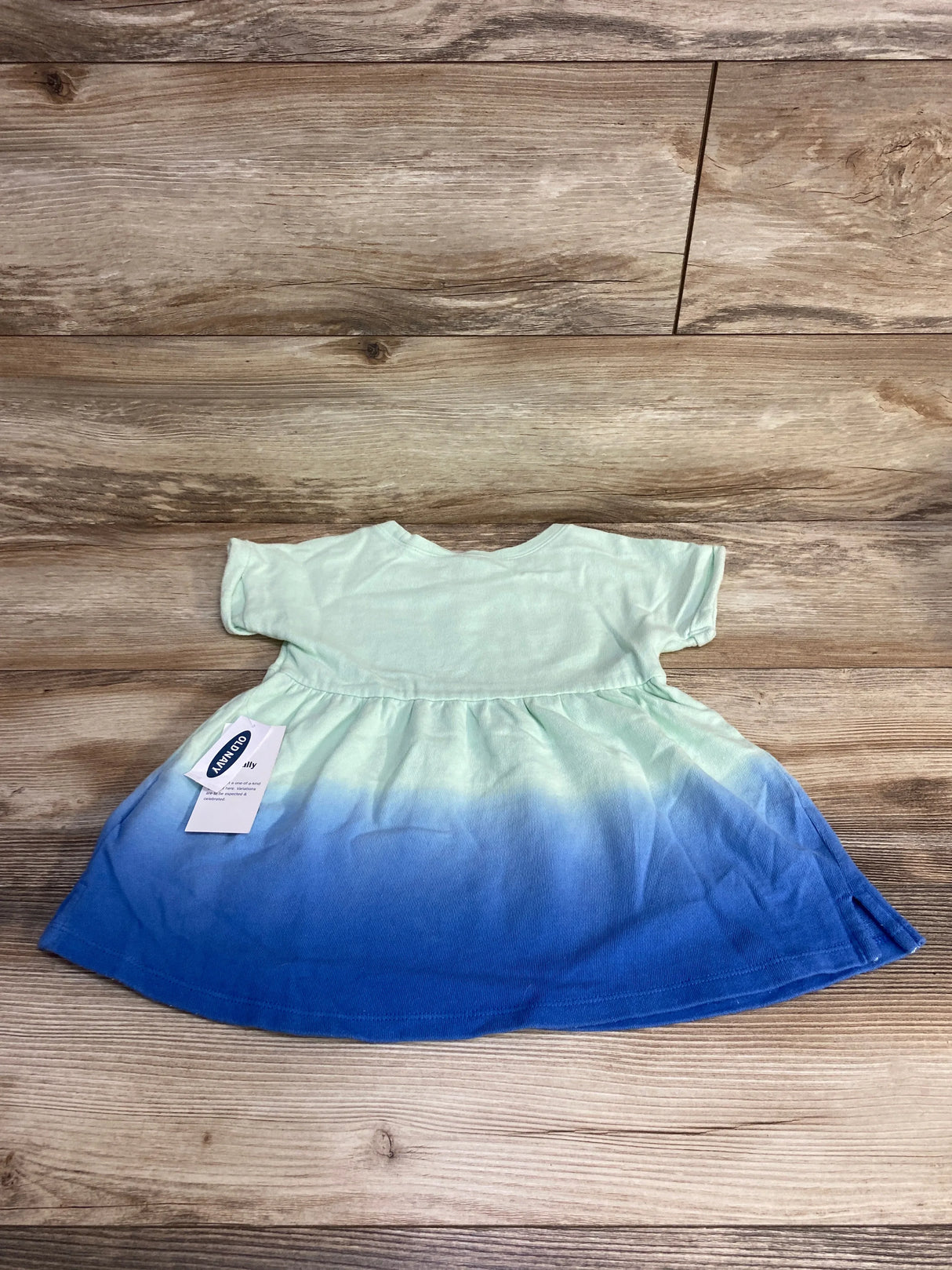 Flat lay of Old Navy size 4T ombre tunic, short-sleeve empire-waist dress in mint to blue on wood background