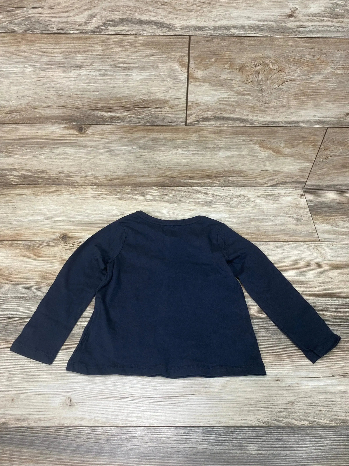 Flat-lay back view of black Baby Gap long-sleeve toddler shirt, size 4T, on light wood background