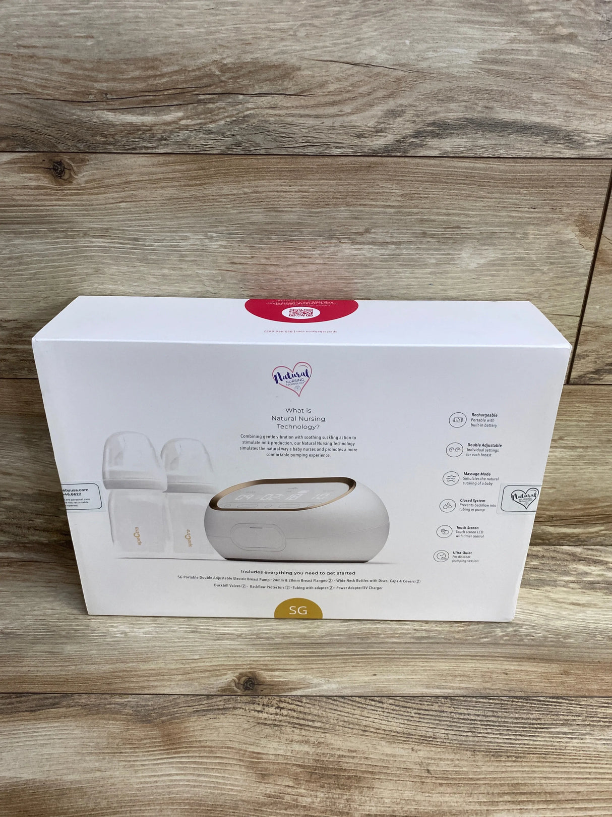 Double electric breast pump kit with bottles and accessories on wood background