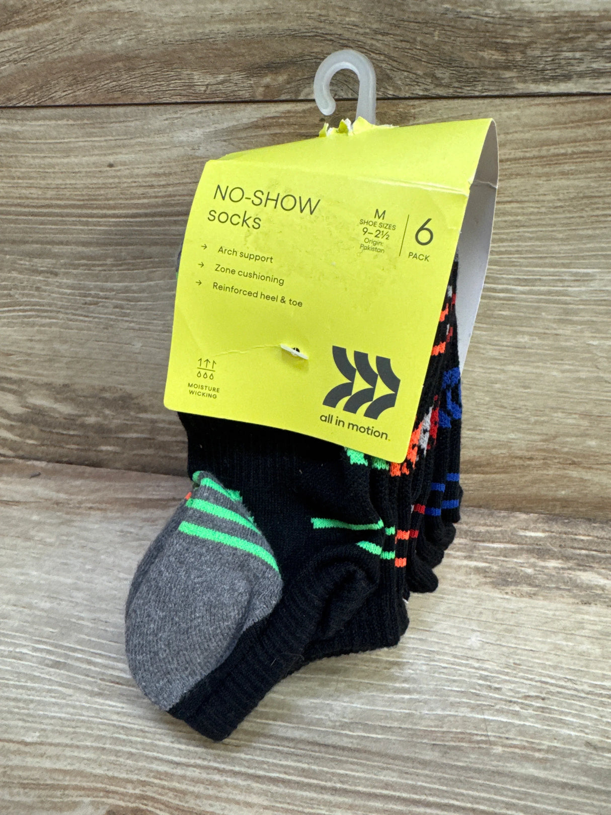 Angled front view of 6-pack no-show socks with yellow label reading NO-SHOW arch support and reinforced heel on wood