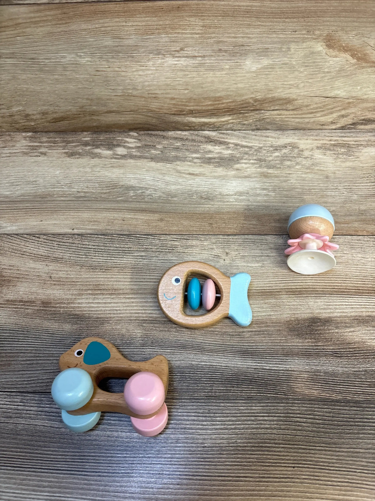 Wooden baby rattles and toys in pastel colors on a wooden surface