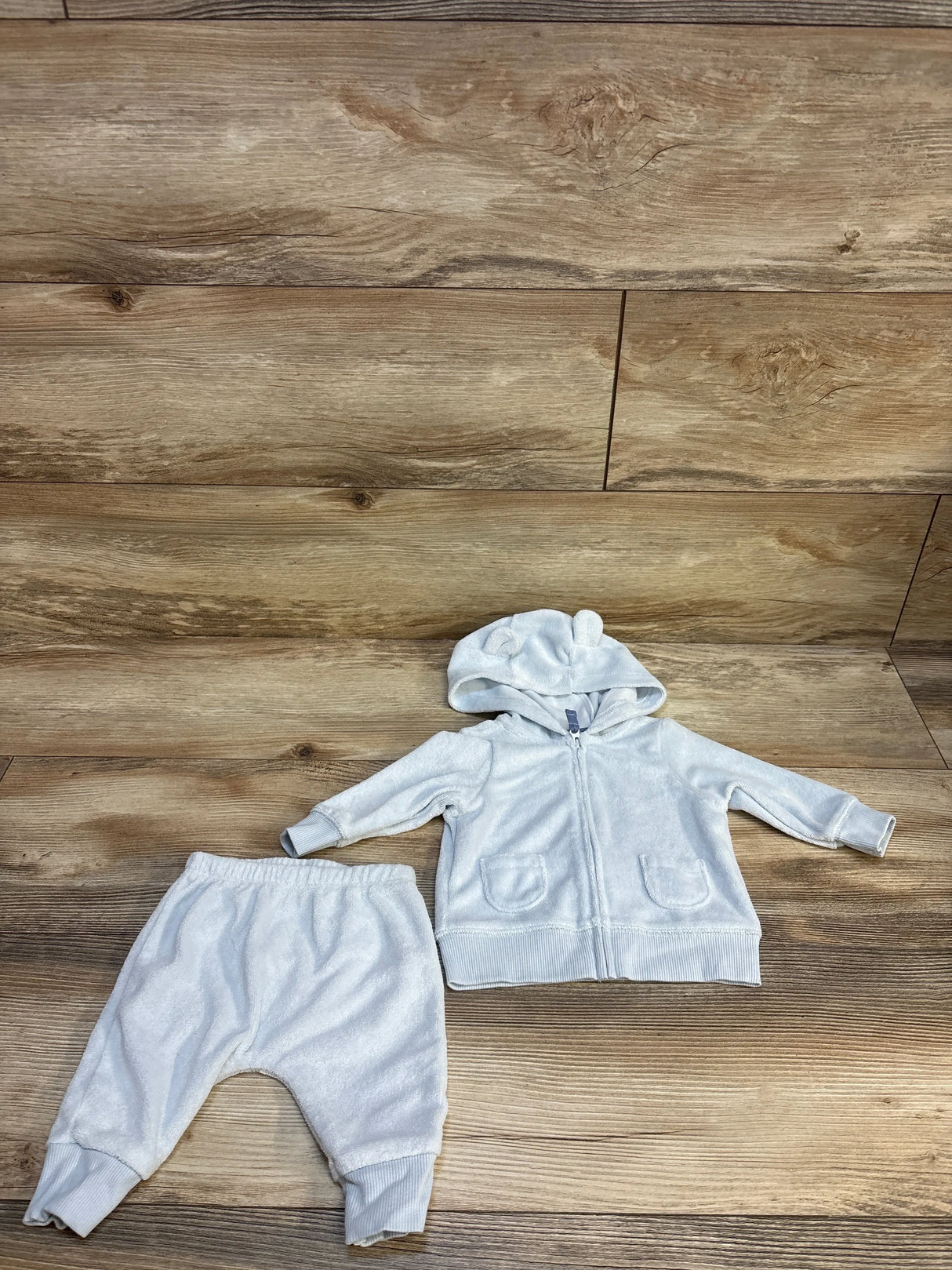 Front view of Carter’s light blue terry cloth full-zip hoodie and joggers set with hood, pockets, and ribbed cuffs