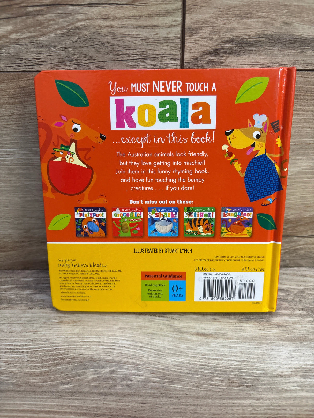 Back of Never Touch A Koala board book with headline ‘Never touch a koala’, colorful characters and thumbnails on wood