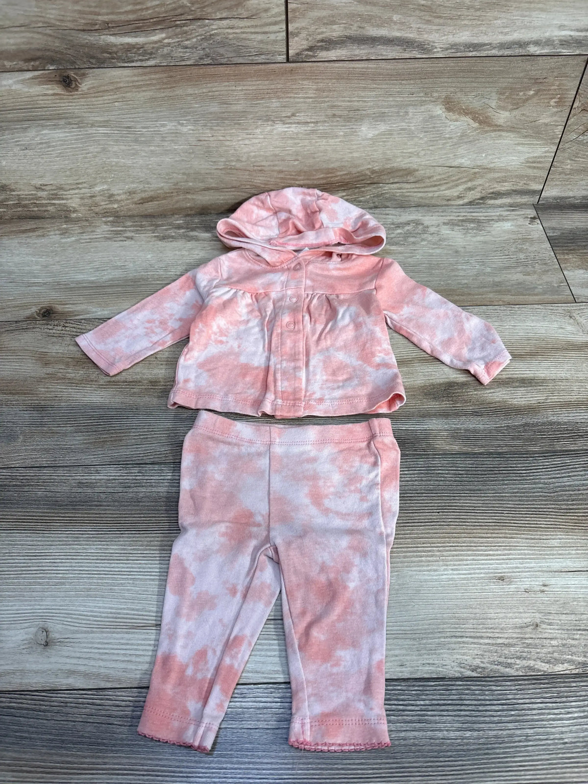 Flat lay of Carters 2pc set in peach tie-dye showcasing hooded tunic top and matching pants on wood plank floor