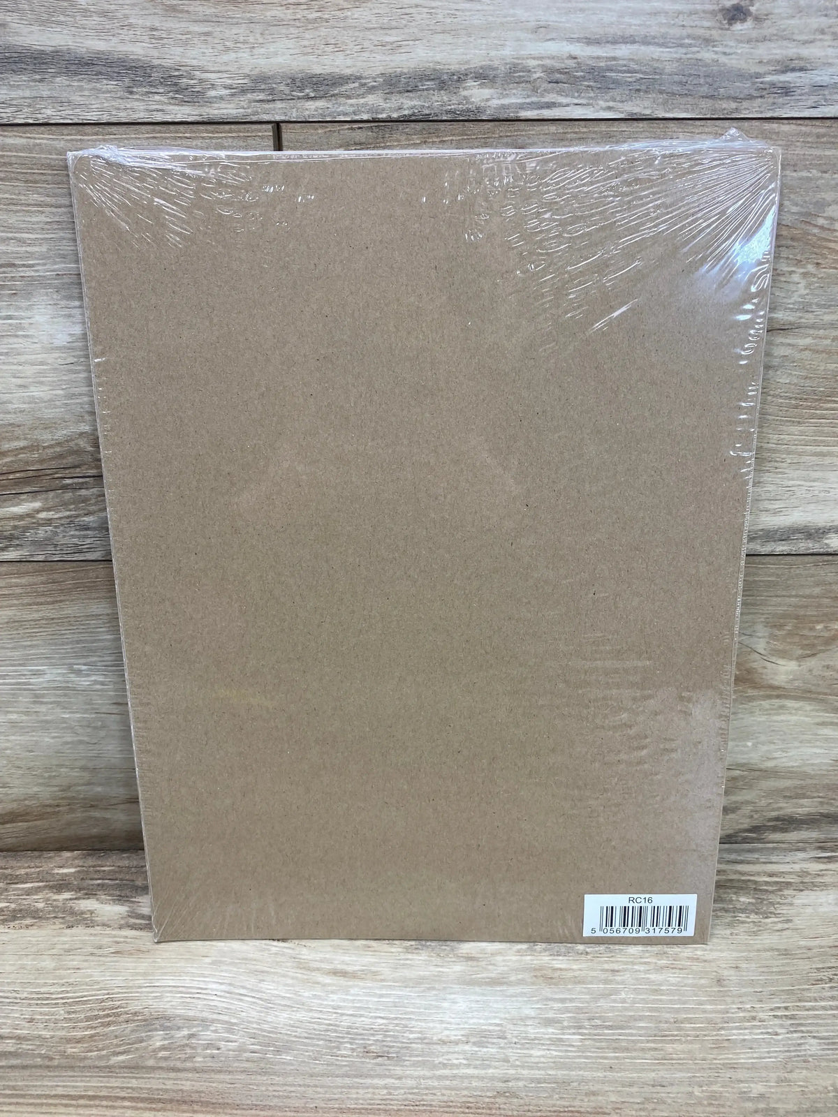 Front view of NEW Central.23 reward chart in shrink wrap showing brown backing and barcode sticker on wood surface