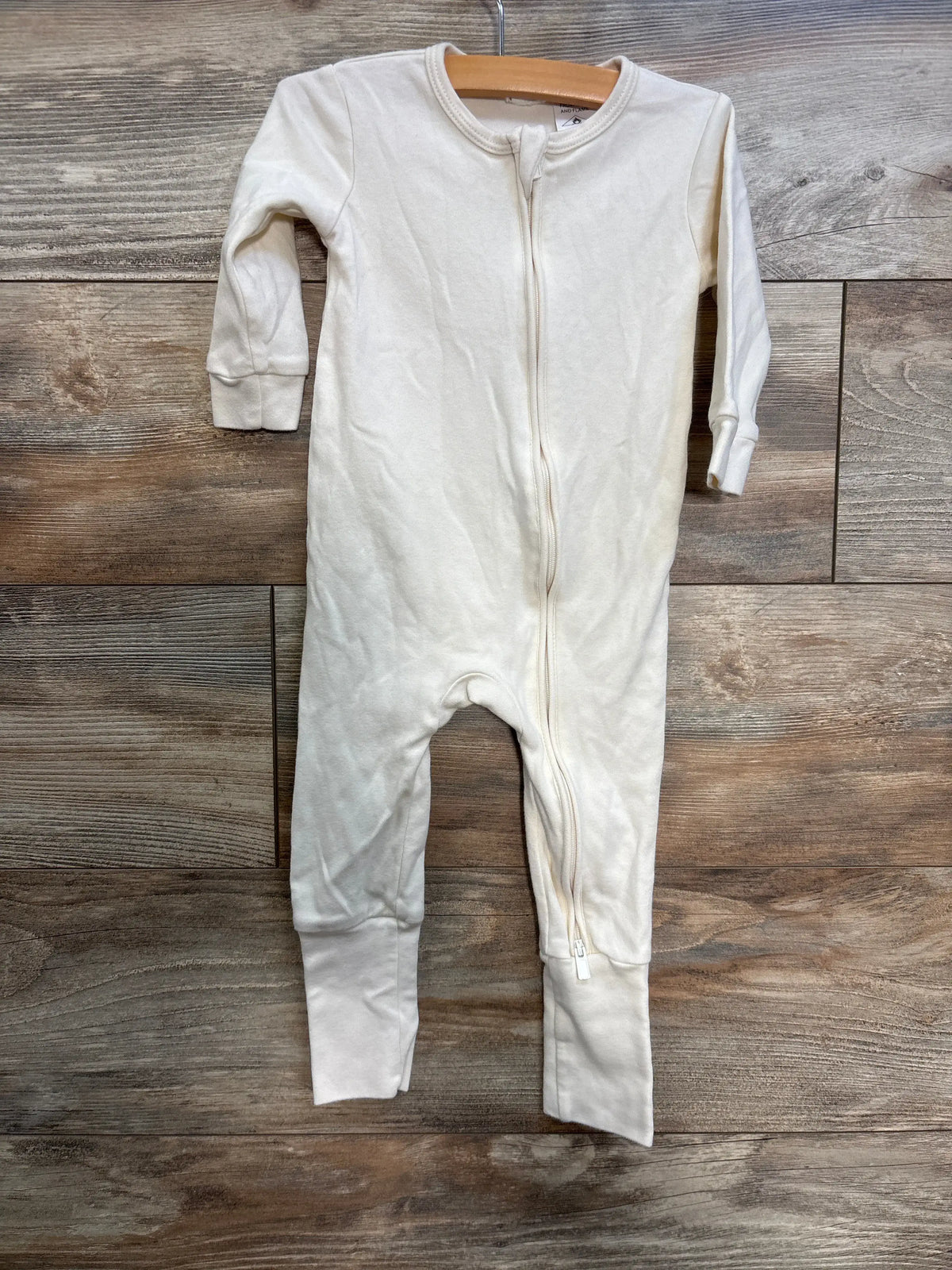 Front view of Jamie Kay cream convertible sleeper showcasing long sleeves and full-length zipper with wood-grain background