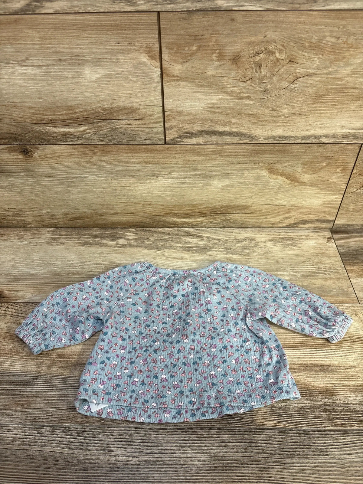 Front view of Carter’s blue floral long-sleeve henley shirt showcasing floral print and henley button placket on white background