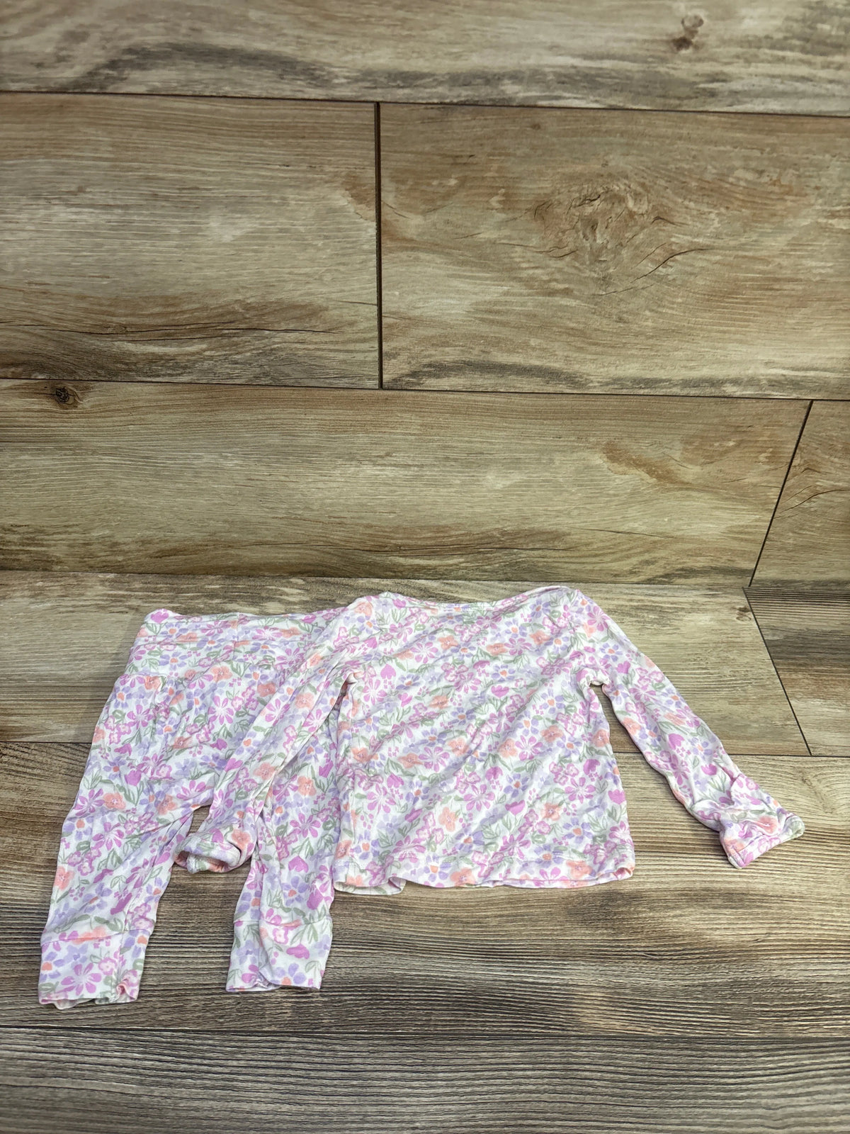 Flat lay of Just One You PurelySoft 2pc floral shirt and pants set showcasing long sleeves on a wood floor