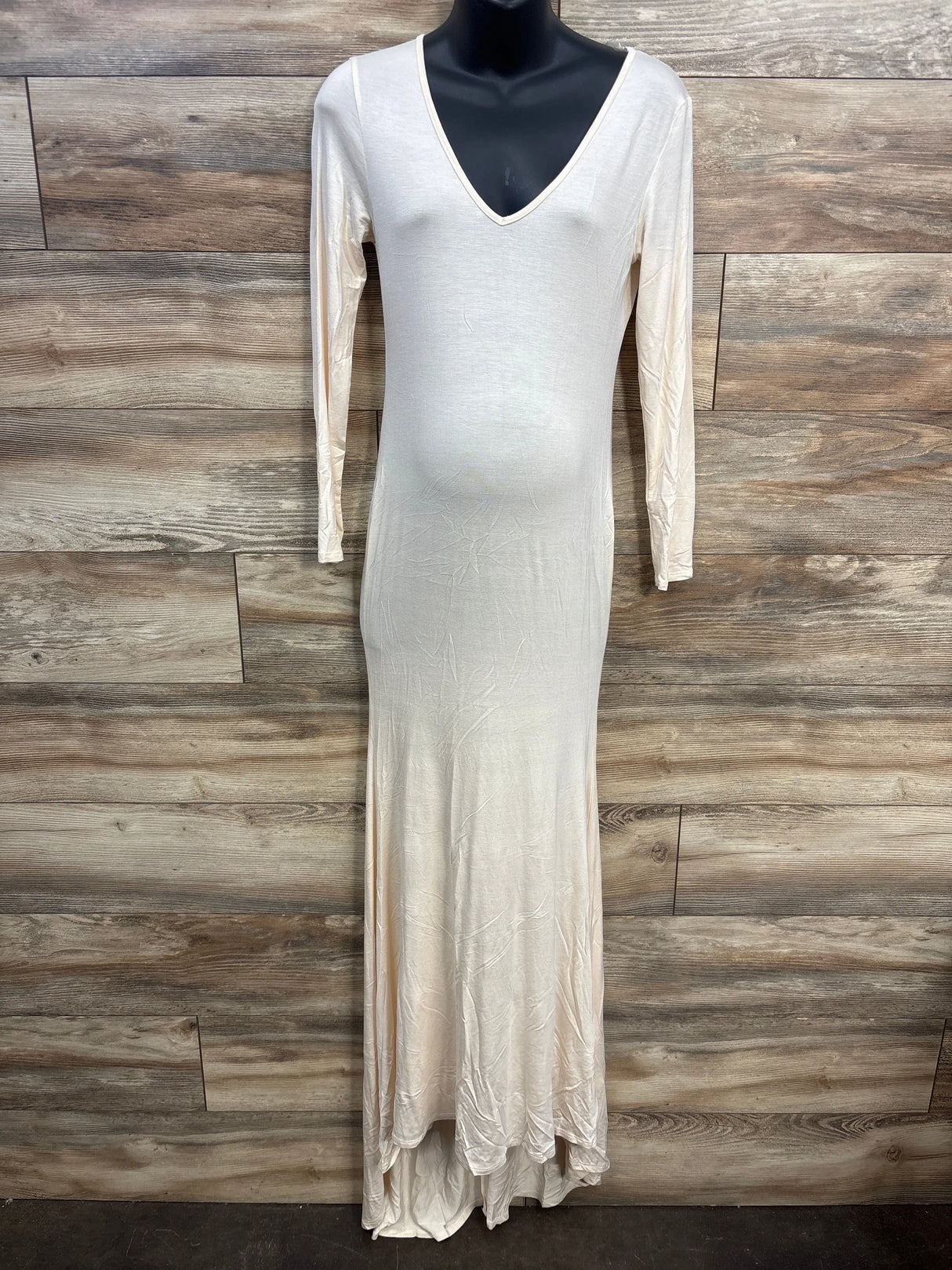Long cream maxi dress with V-neck and long sleeves on mannequin against wood background