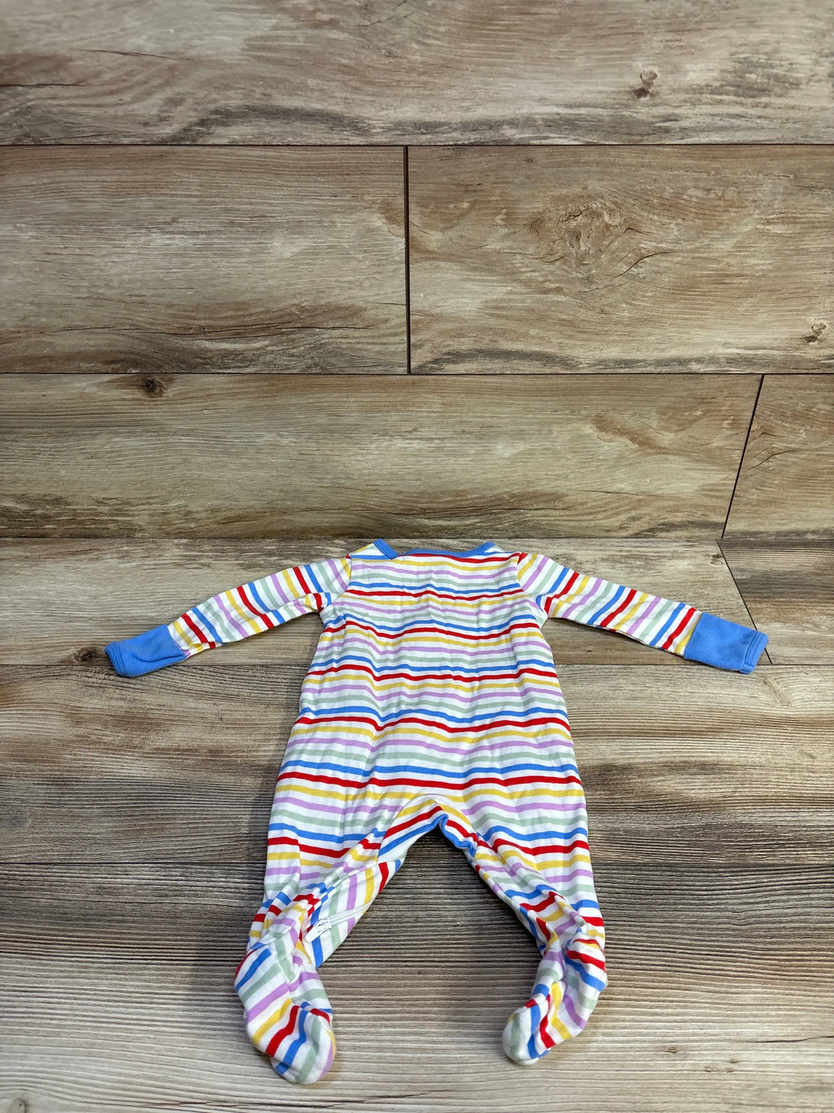 Front view of Wonder Nation striped sleeper showcasing multicolor horizontal stripes and covered feet on a wood-look background