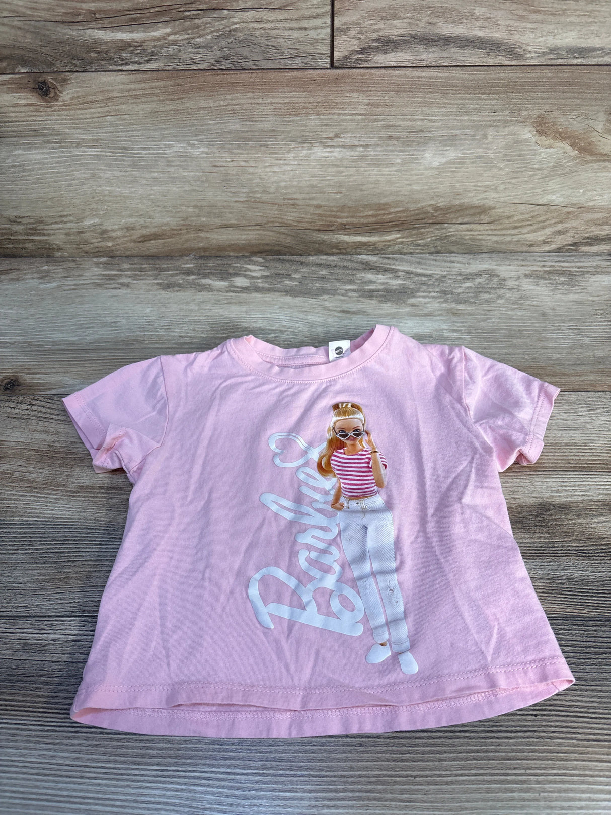Light pink Barbie graphic girls' T-shirt with character print, kids clothing flat lay