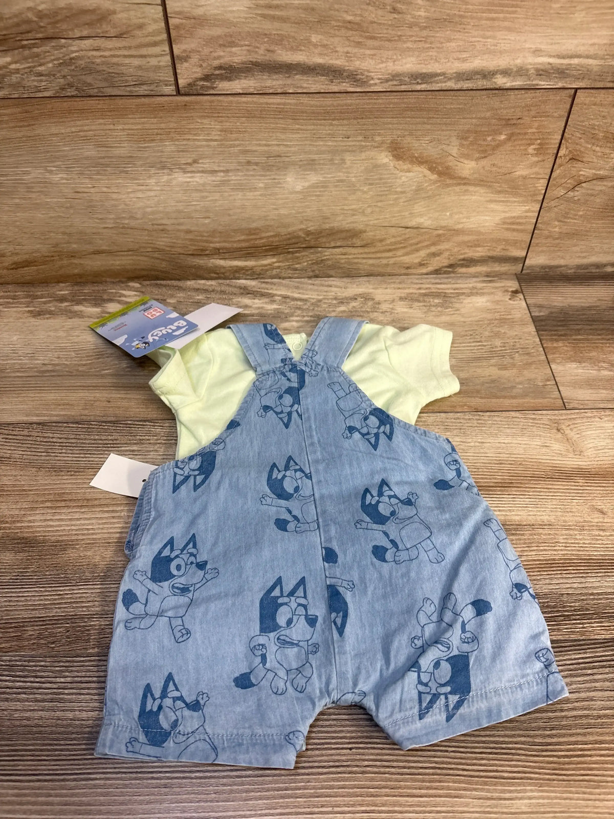 Bluey baby romper with denim print and yellow top, kids clothing set on wood floor