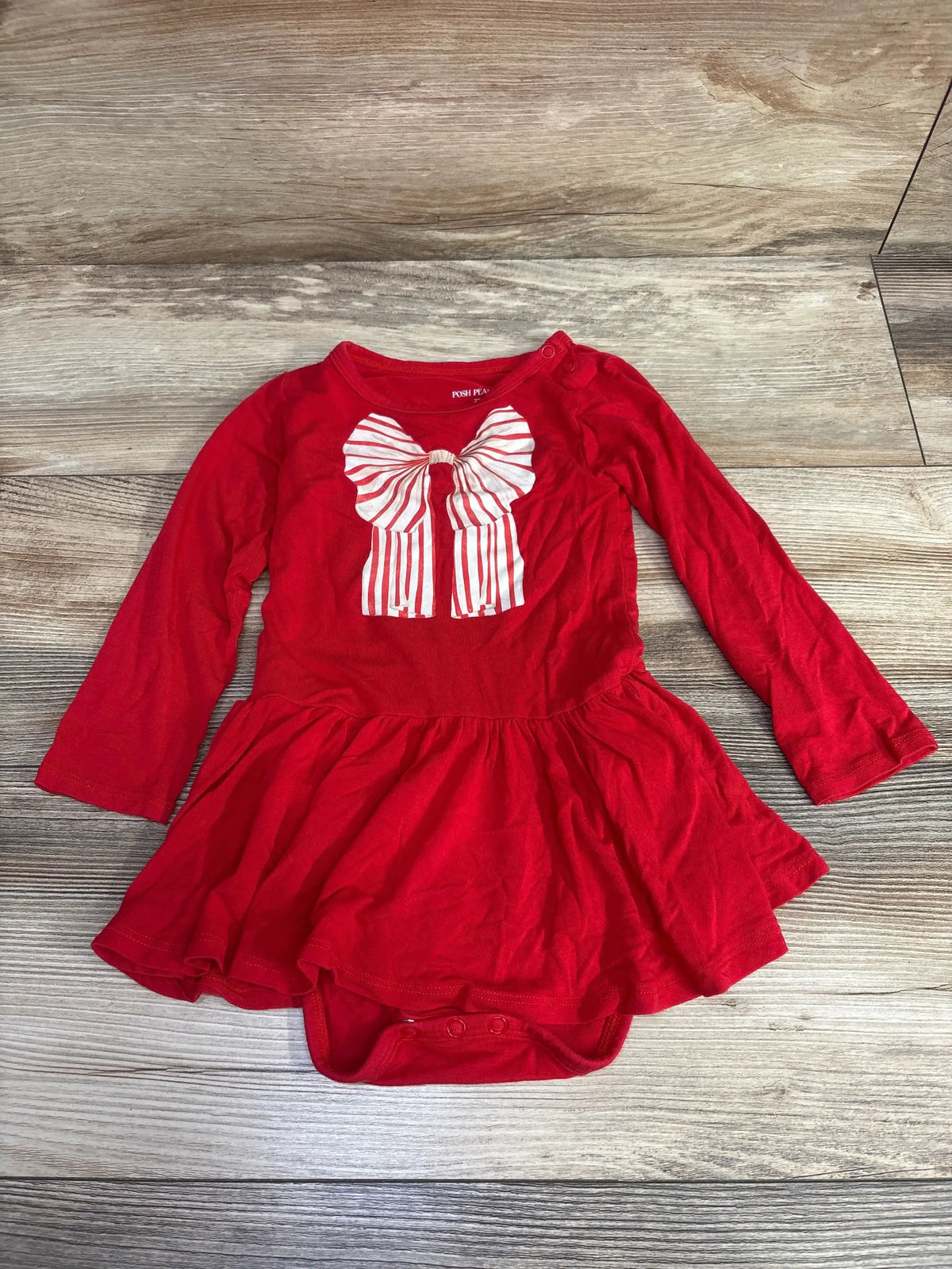 Red baby dress with striped bow, long sleeves, and ruffled hem for festive occasions