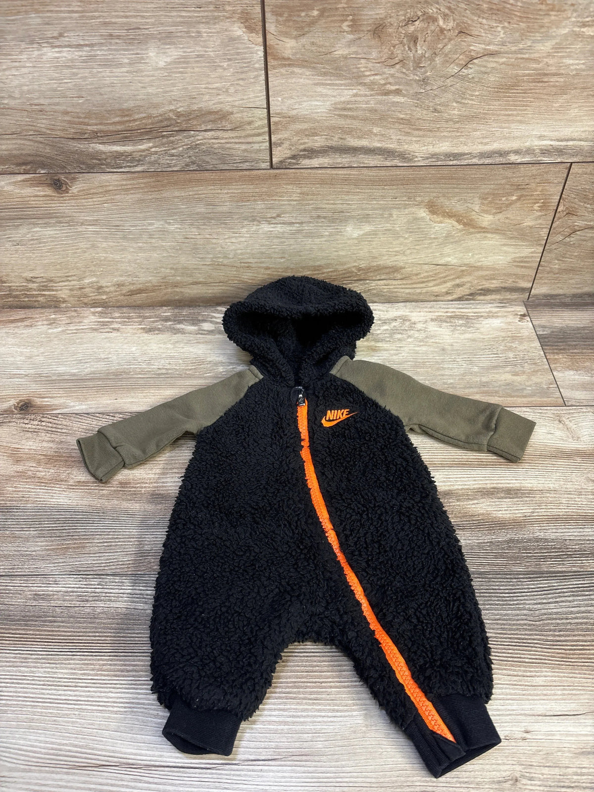 Nike sherpa hooded coverall for newborns in black with olive sleeves and orange zipper detail