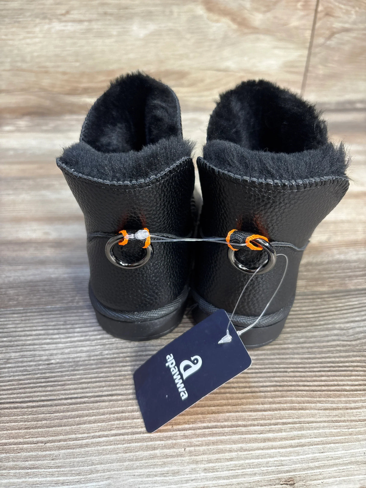 Black toddler boots with faux fur lining, Apawwa tag, on wood floor