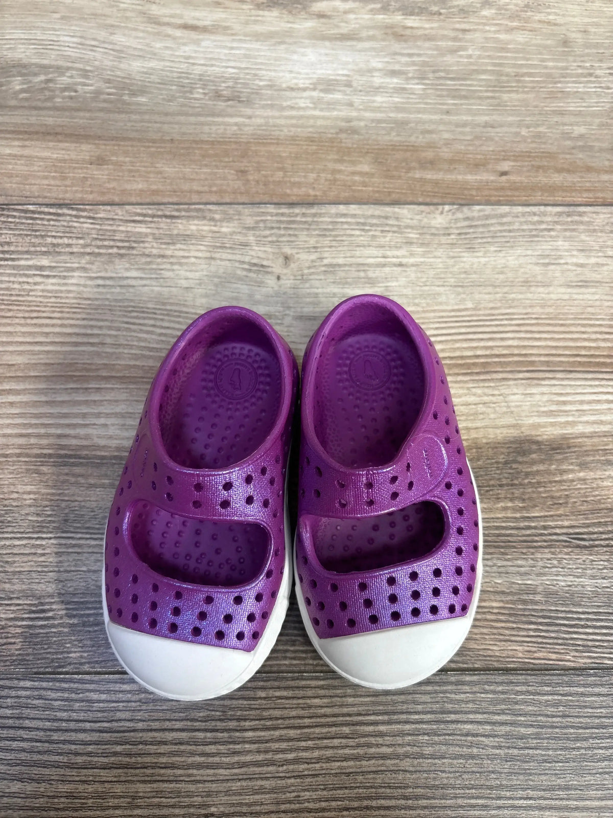 Top-down view of purple Native Jefferson Juniper toddler shoes size 4C showing perforated upper and white toe cap on wood floor