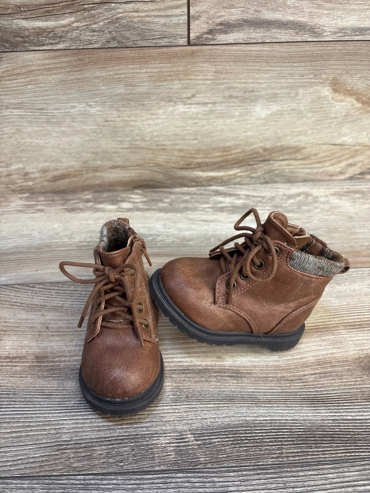Brown toddler lace-up boots with knit collar on wooden floor