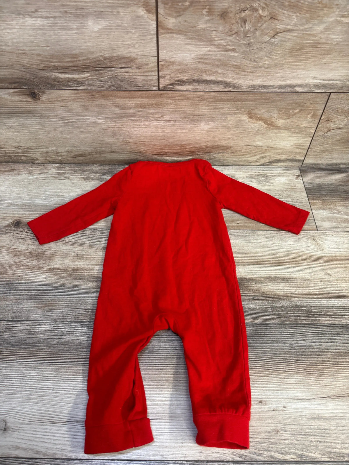 Flat-lay view of a red Cat & Jack Little Love coverall showcasing long sleeves and cuffed legs on a wood-look floor