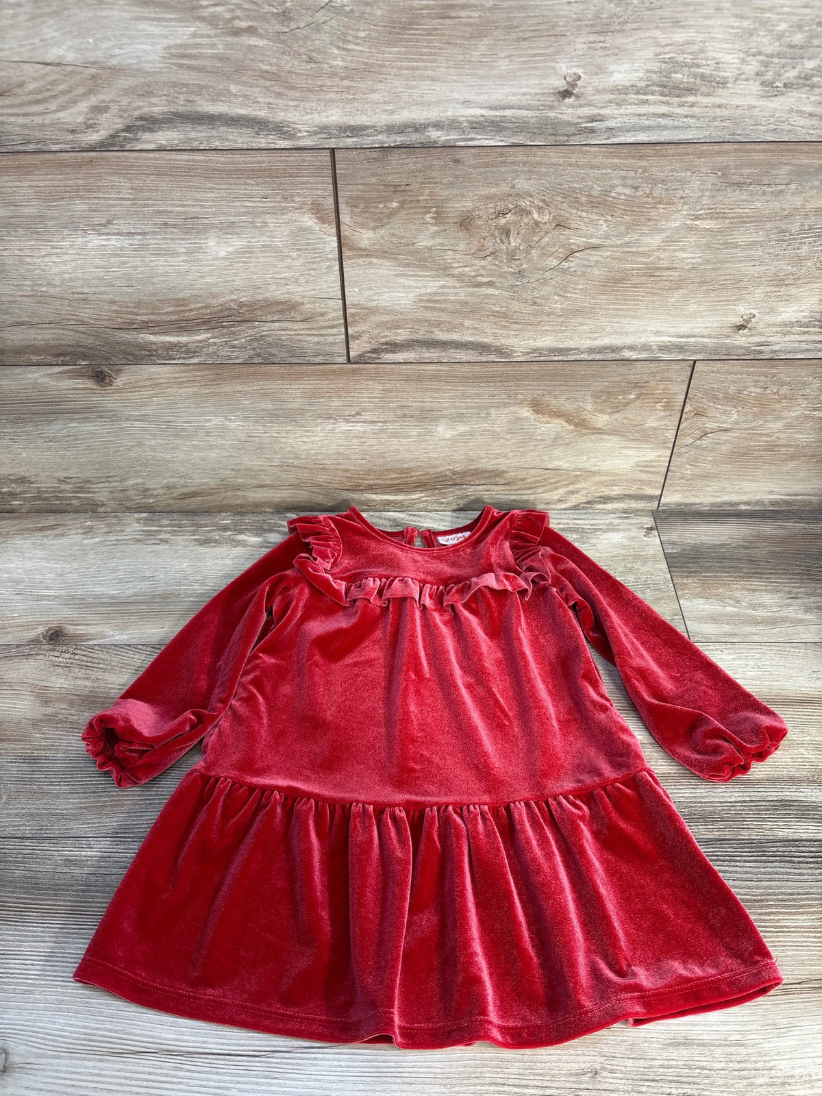 Front view of Cat & Jack red velvet ruffle dress in size 3T showcasing long sleeves and gathered skirt on a wood floor