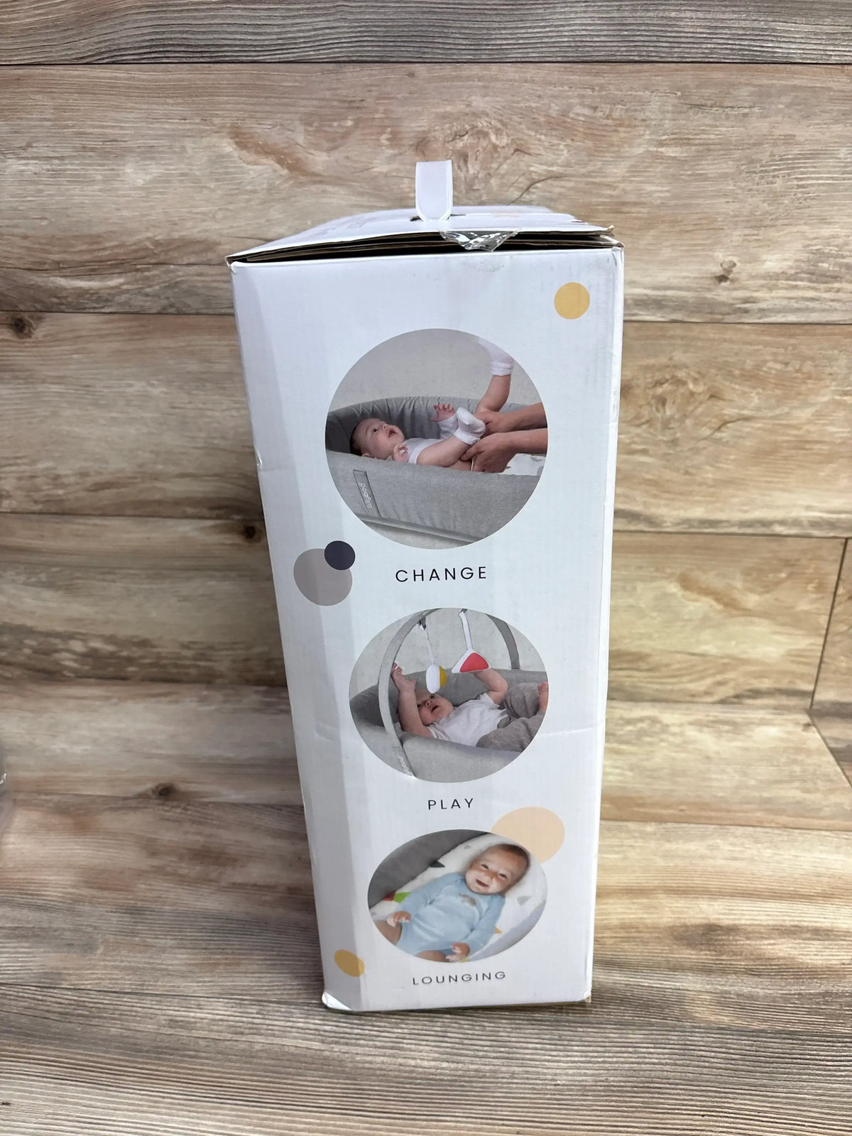 Baby activity lounger packaging showing baby changing, play, and lounging functions