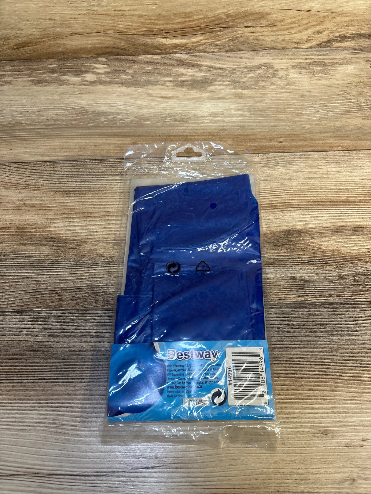 Blue Bestway inflatable pool accessory in clear packaging on wood background