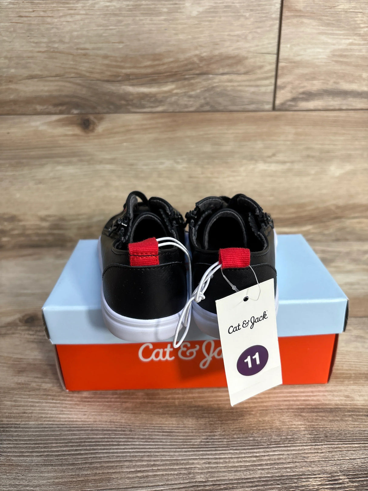 Cat & Jack black youth sneakers with red heel accents, size 11, on branded box